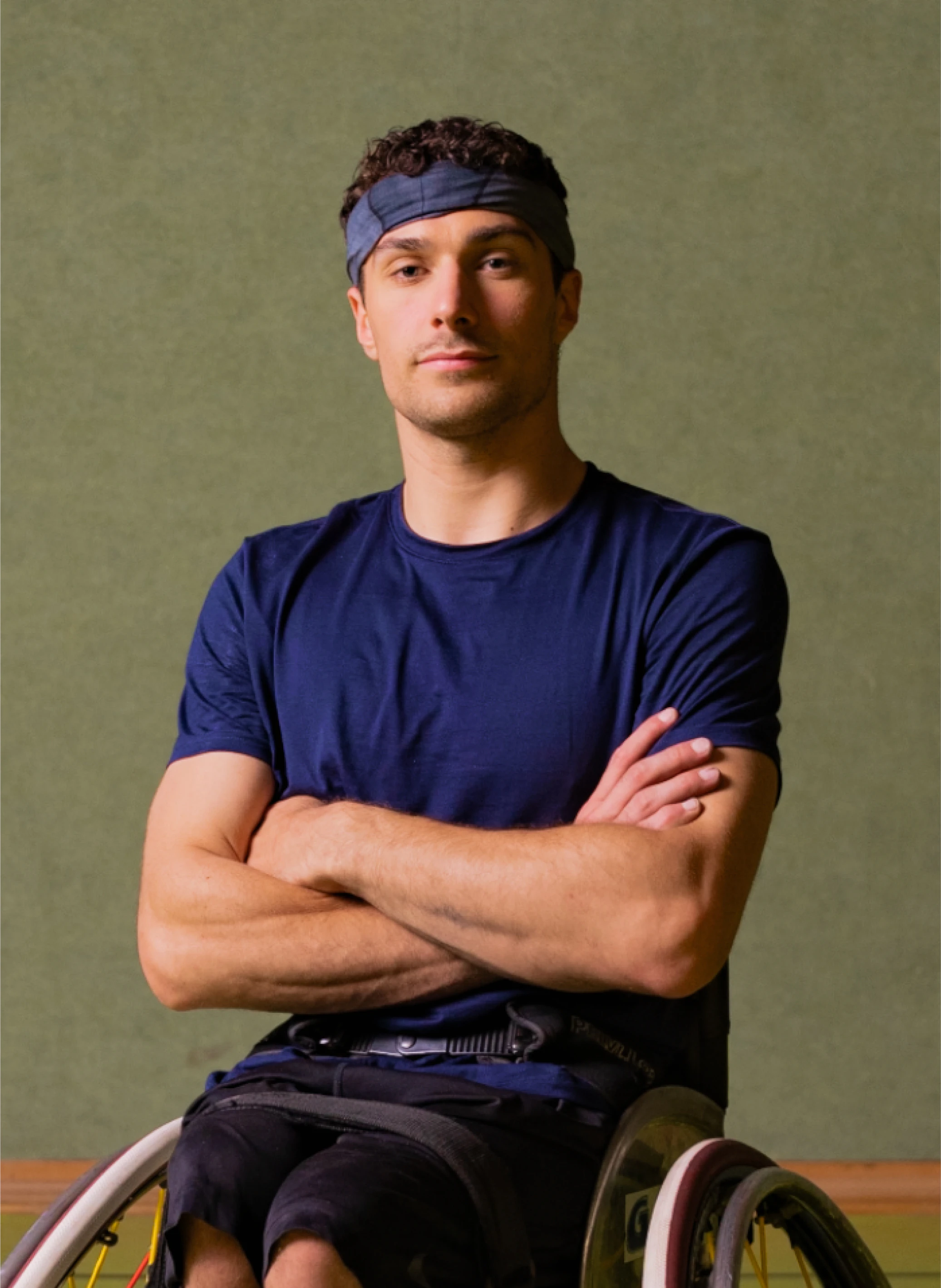 Portrait of Nico Dreimüller, a determined male athlete in a wheelchair, arms crossed. Great for content creators looking for inspiring stock footage and sound effects.