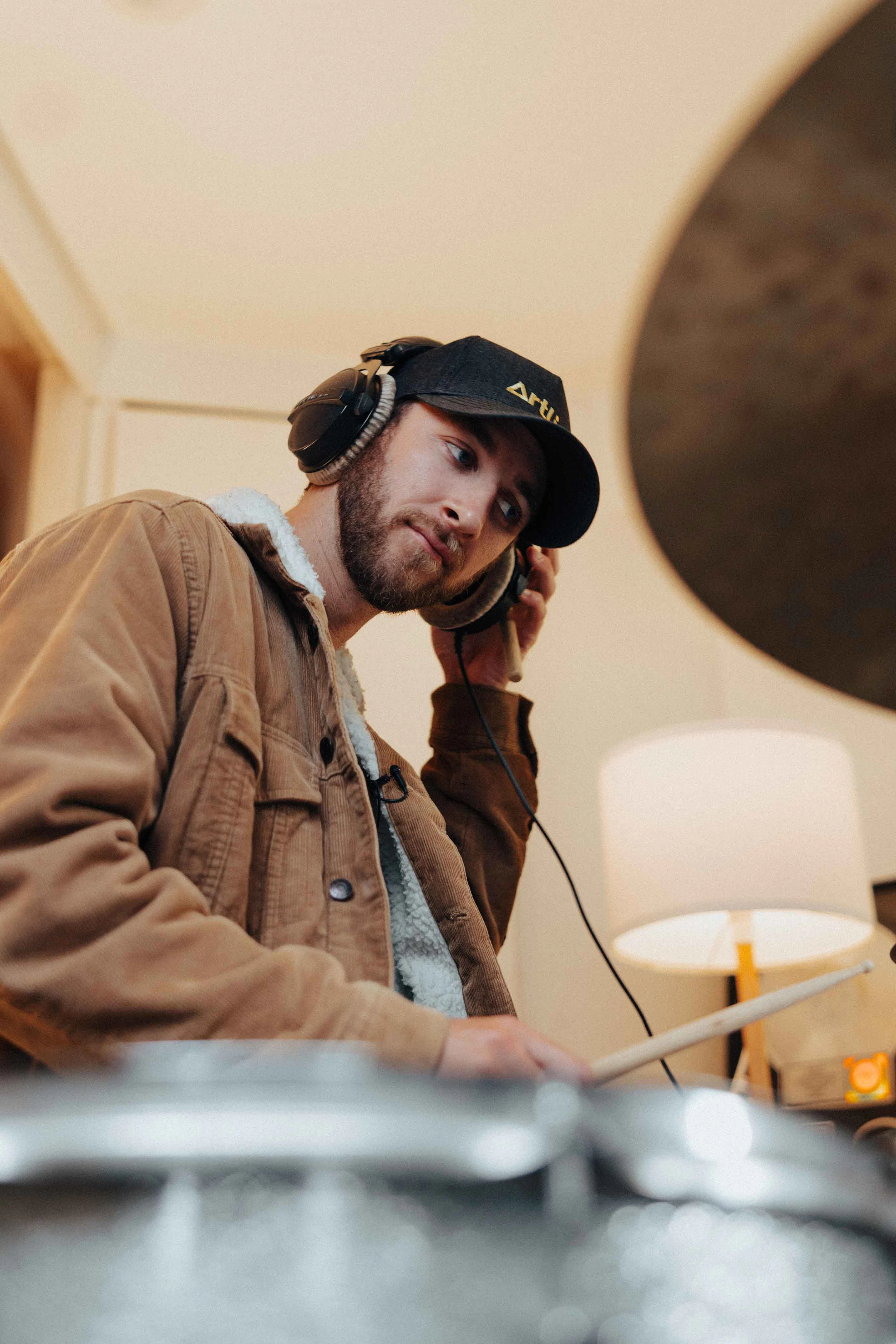 Sam Newton sitting at a drumkit in the recording studio, create a royalty-free song for Artlist